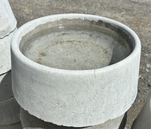 Close-up of a concrete dog bowl with water, showcasing its smooth finish and modern design