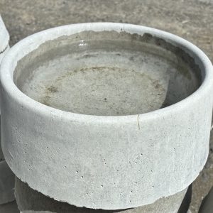 Close-up of a concrete dog bowl with water, showcasing its smooth finish and modern design